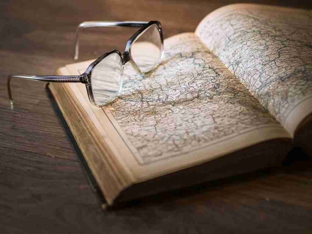 Atlas Book Open with maps and glasses on top