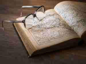 Atlas Book Open with maps and glasses on top